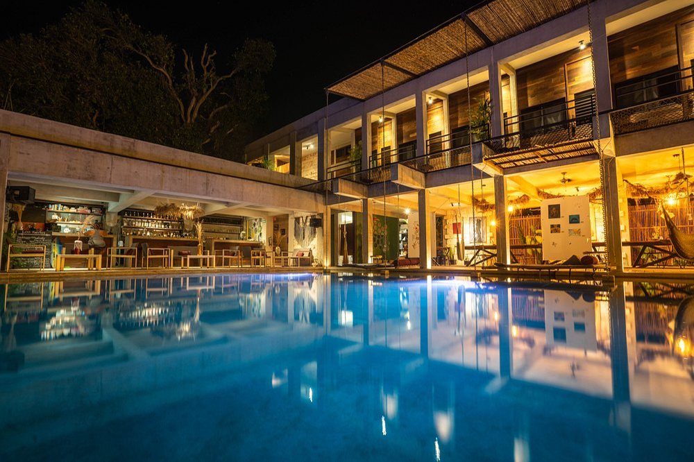 Alberca de Makaabá de noche, con el restaurante y las habitaciones iluminadas, en Bacalar