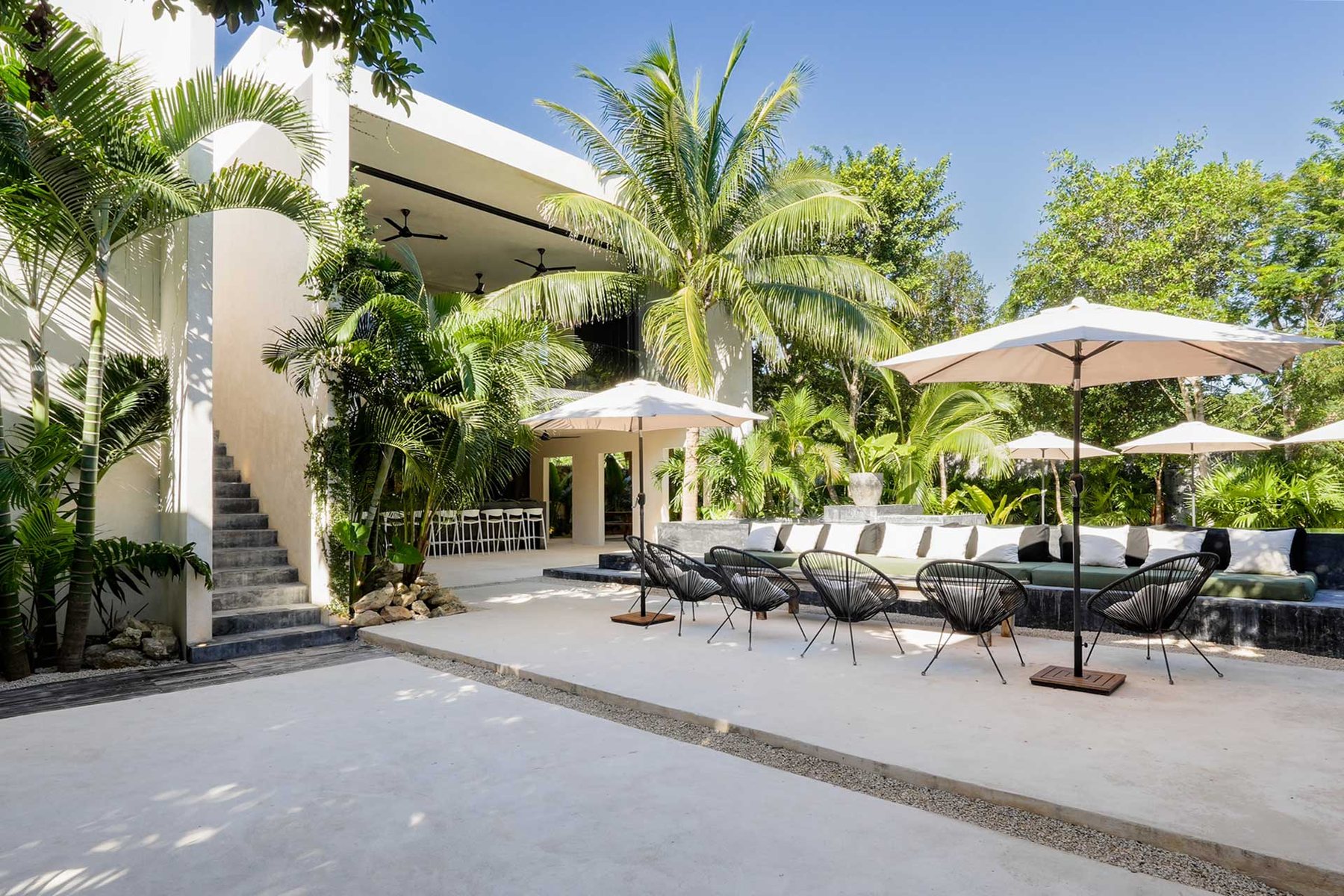 Terraza con sombrillas y sillas junto a la casa