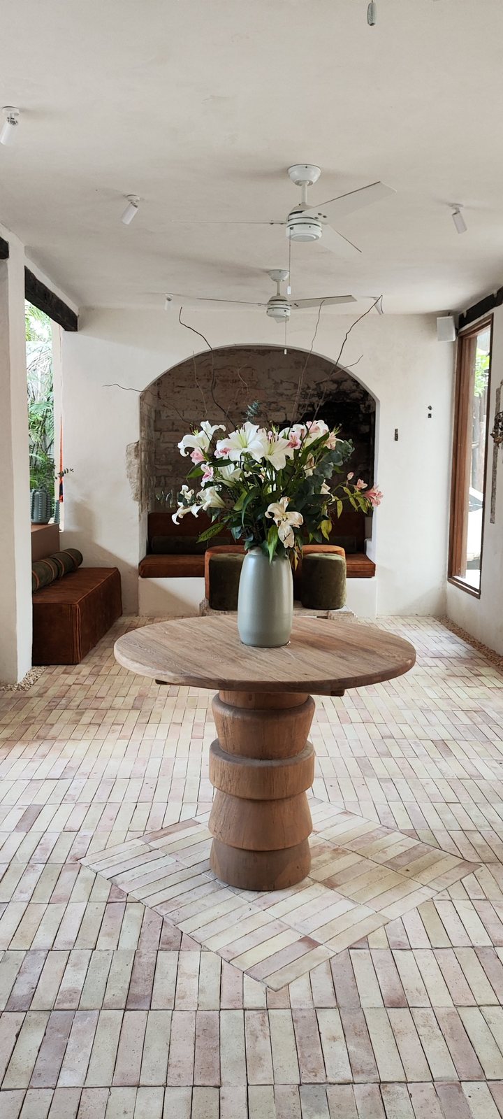 Salón con arco, mesa de madera y bocinas discretas en los muros
