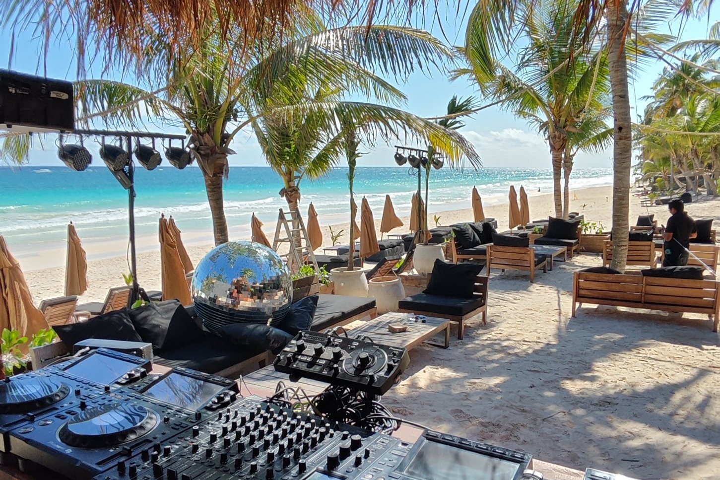Cabina de DJ bajo palapa con vista a la playa