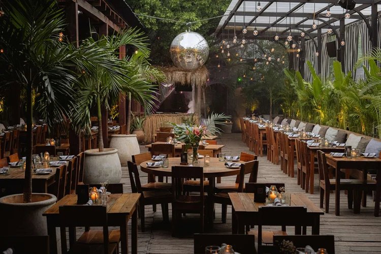 Comedor bajo pérgola con bola de espejos y luces colgantes
