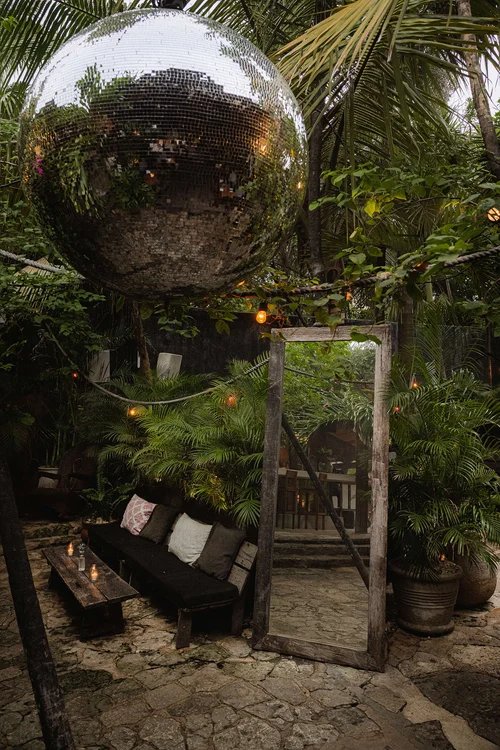 Lounge en la selva con bola de espejos y espejo de madera