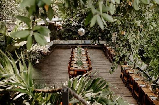 Mesa larga montada en la terraza de madera entre la selva