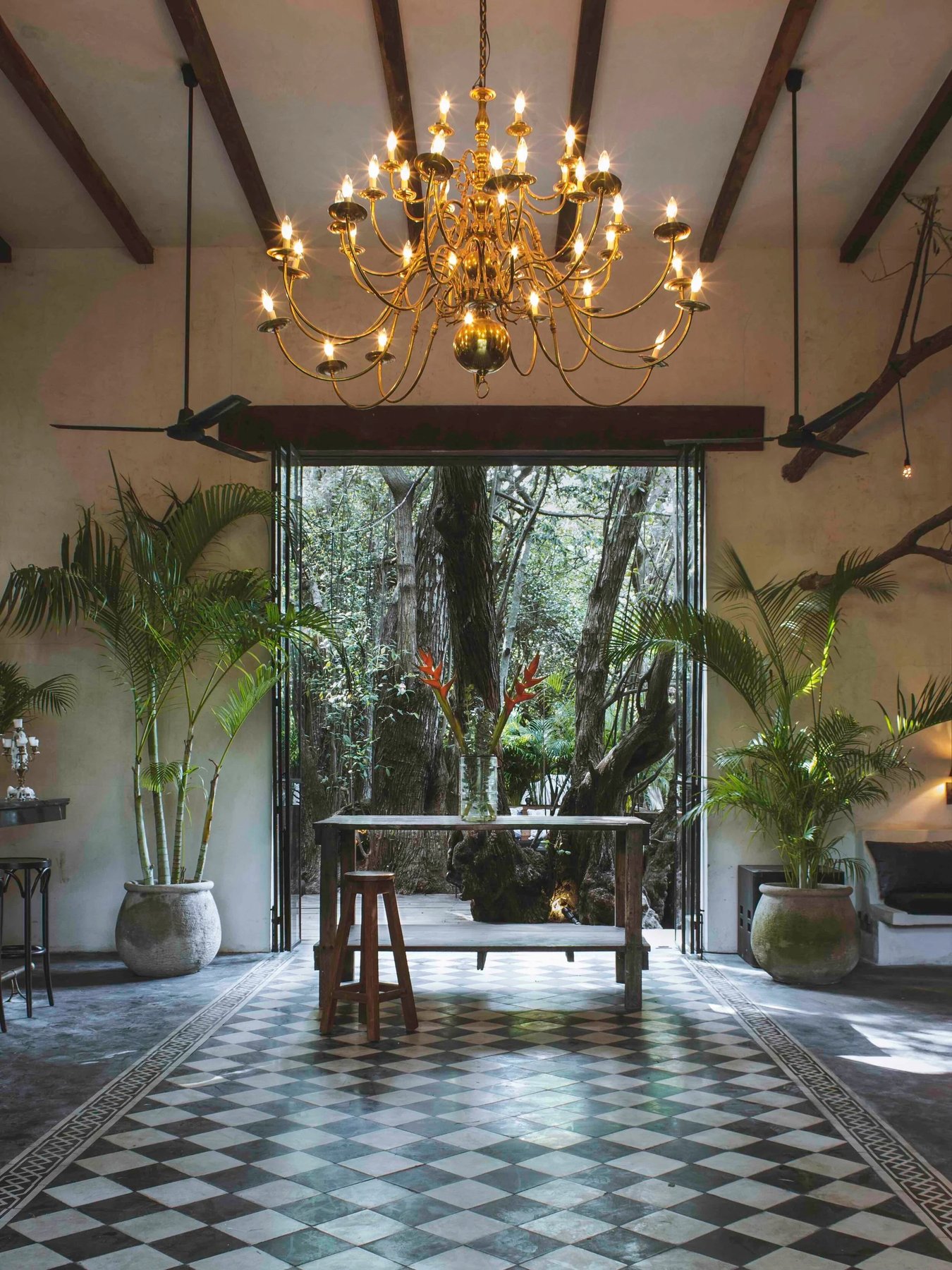 Salón con candelabro y piso de damero abierto a la selva