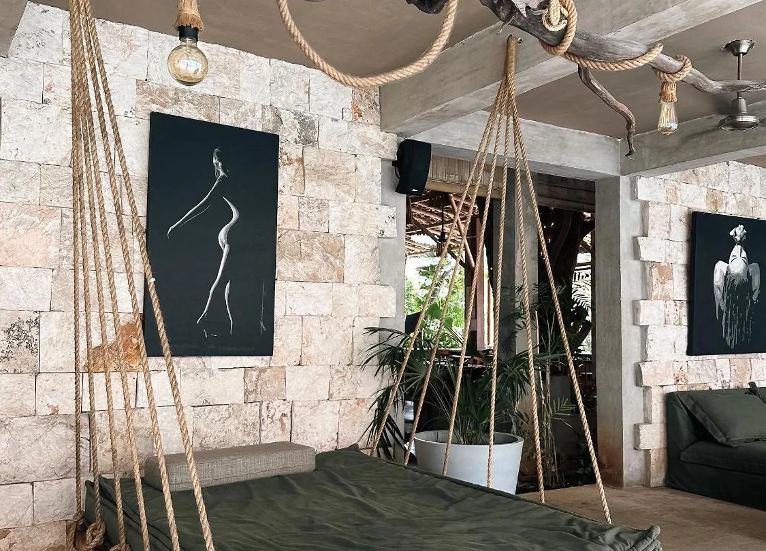 Lounge con muros de piedra y bocina montada en la columna